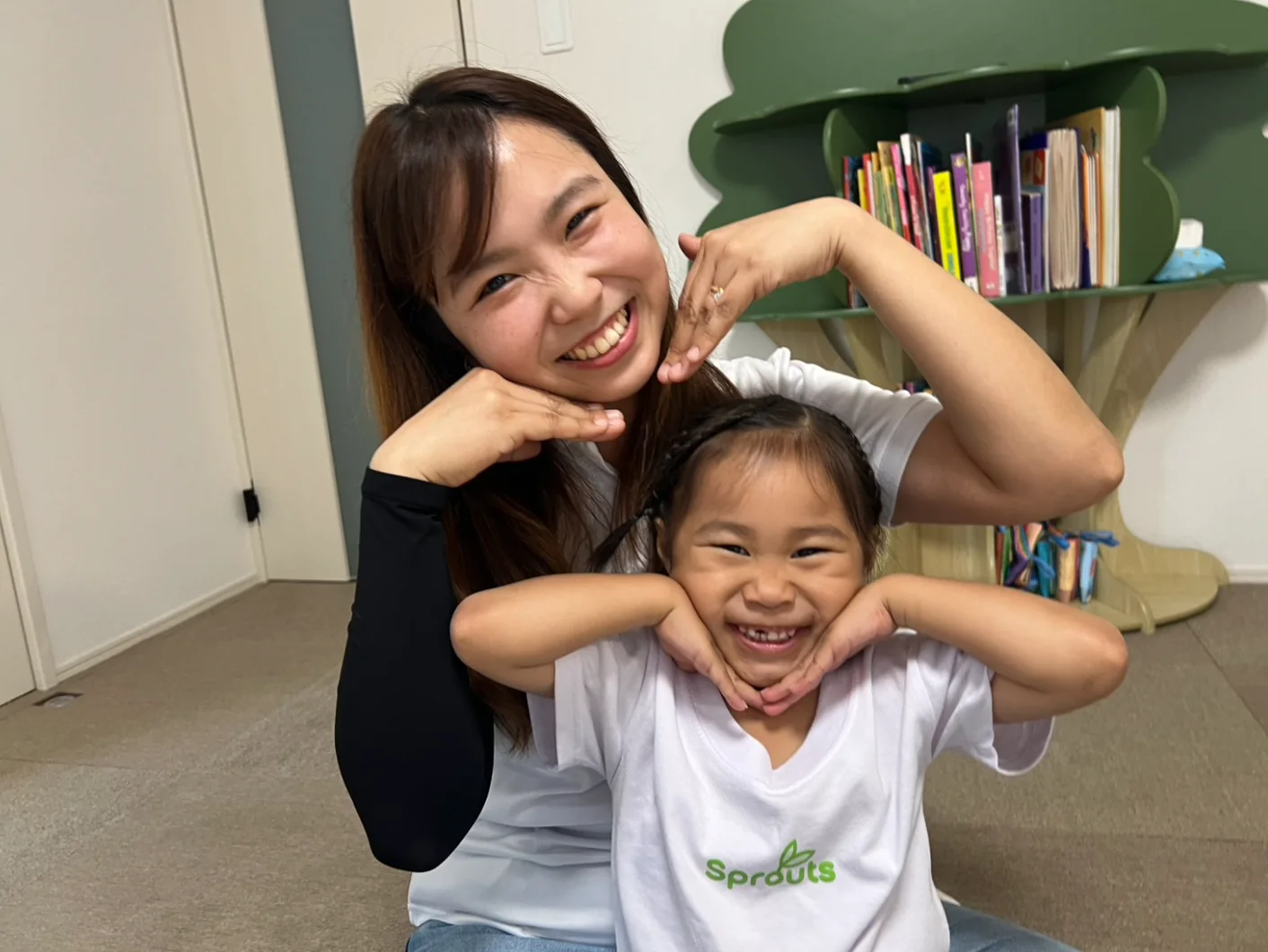 先生と子どもが笑顔で向き合い、安心した雰囲気の中で英語にふれている様子